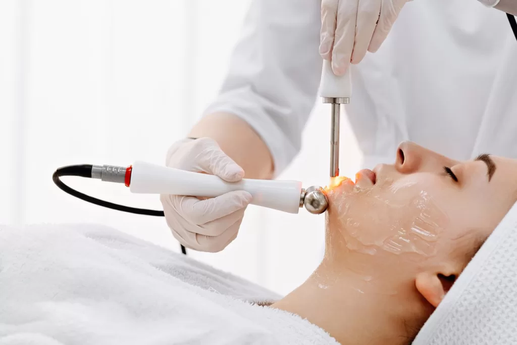 Women undergoing professional laser and radiofrequency facial treatments at a medical spa to restore skin vitality.